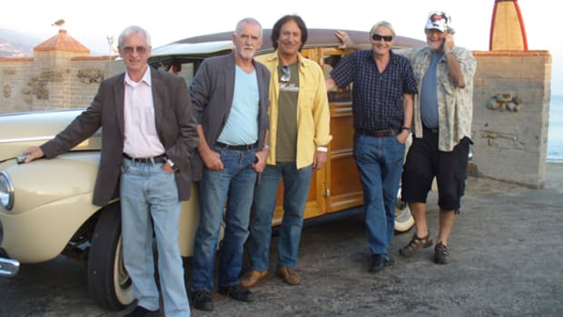 The Malibooz’ John Zambetti (center, above), wasn’t afraid to pull out all the stops — including his wife’s good cooking and a trip to the beach in his 1941 Ford woodie station wagon —to persuade Quarrymen members Colin Hanton, Len Gary and Ron Davis to take part in The Malibooz’ new album “Queen’s English.” Photo courtesy www.malibooz.net