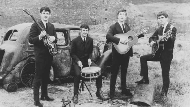 A very young Fab Four get down and dirty at a junkyard for this early press photograph . Photo courtesy of Parlophone/Apple Corps Ltd.