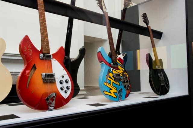 Some of the guitars displayed in the exhibition are shown here, with the one in the center giving evidence of the band’s interest in pop art. (Photo by Dean Fardell for Nicetime Productions)