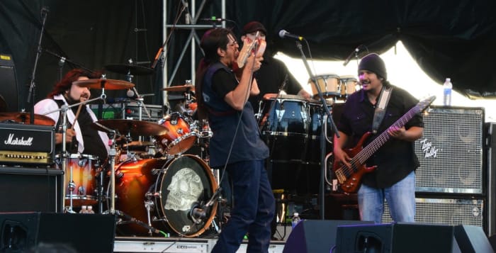 Los Lonely Boys guitarist Henry Garza takes a Jimi Hendrix-type approach to his instrument while brothers and bandmates Ringo (left) and Jojo watch. (Photo by Chris M. Junior)