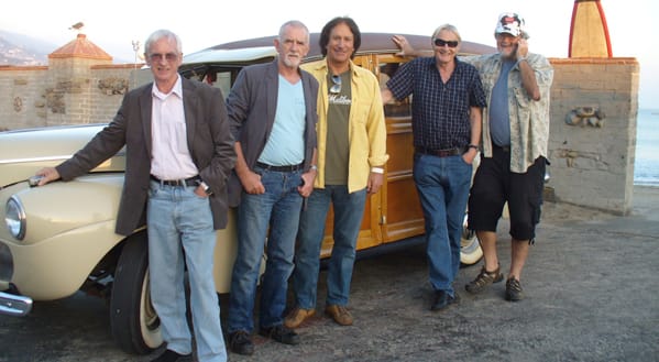 The Malibooz’ John Zambetti (center, above), wasn’t afraid to pull out all the stops — including his wife’s good cooking and a trip to the beach in his 1941 Ford woodie station wagon —to persuade Quarrymen members Colin Hanton, Len Gary and Ron Davis to take part in The Malibooz’ new album “Queen’s English.” Photo courtesy www.malibooz.net