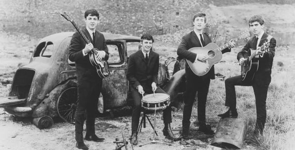 A very young Fab Four get down and dirty at a junkyard for this early press photograph . Photo courtesy of Parlophone/Apple Corps Ltd.