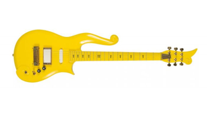 A Yellow Cloud guitar custom made and stage played by Prince. The guitar has black Love Symbols down the neck and a plaque on the back that reads "Property of PRN Music Corp." Serial number 16212. Accompanied by a signed letter of authenticity on Paisley Park Enterprises letterhead from Jenifer Carr, director of finance and operations, stating that the guitar has been used in rehearsals and performances all over the world. The guitar is housed in a hardshell case.