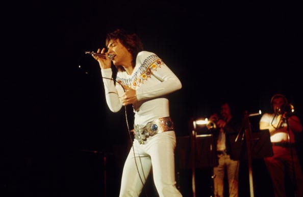David Cassidy performs on stage in 1975 in Amsterdam, Netherlands. (Photo by Gijsbert Hanekroot/Redferns)