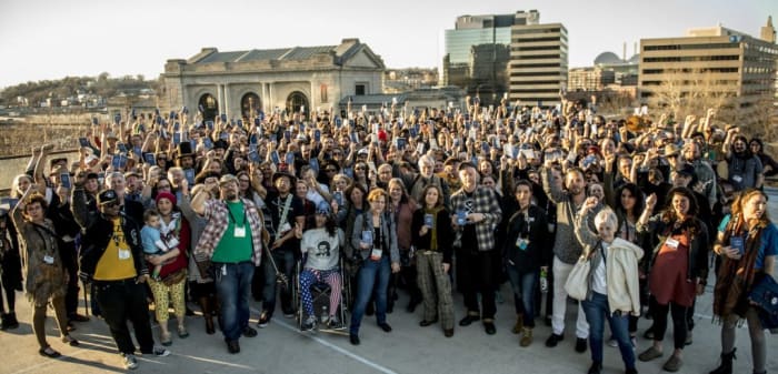 Attendees raise pocket U.S. Constitutions from the Folk Alliance swag bag atop the Westin Crown Center with Ani DeFranco and Billly Bragg, February 17, 2017. Photo credit: Jayne Toohey