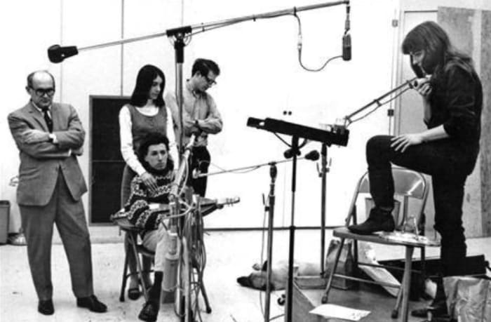Richard Fariña seated, Judy Collins furthest right at the microphone. 1960s recording studio photo courtesy of Judy Collins.