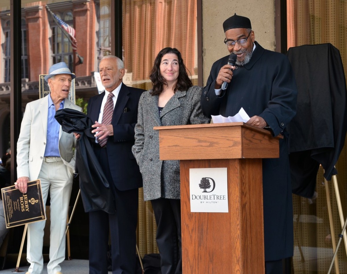 The daughter of songwriter/producer Jerry Ross looks on as Kenneth Gamble reads a speech written by her father during the Oct. 24 Philadelphia Music Alliance's Walk of Fame ceremony. Longtime Philadelphia DJ and event MC Jerry Blavat is at the far left. Next to him is Joe Tarsia, the PMA's chairman of the board and the founder of the Sigma Sound recording studio. (Photo by Chris M. Junior)