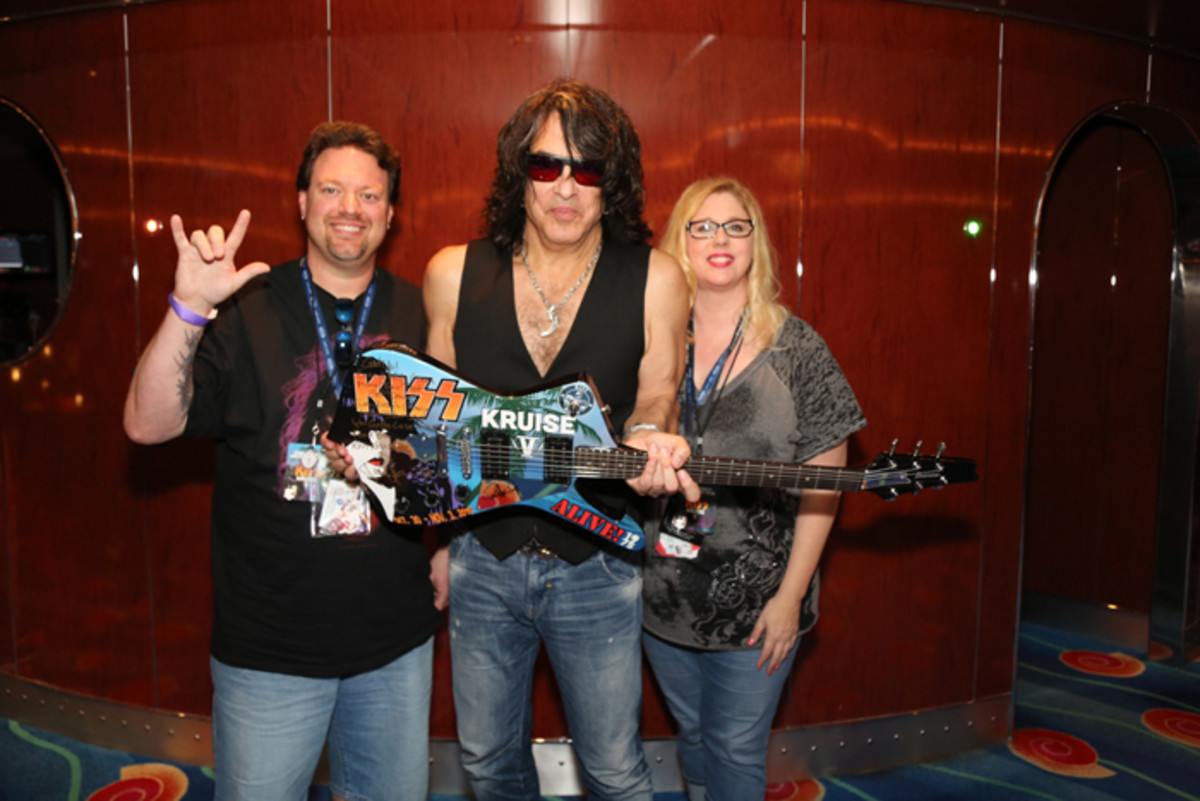 Fans get exclusive acces to their favorite groups on band cruise ships. Here is Paul Stanley with KISS KRUISE V guitar and fans Ryan Barks and Angela Simmons.