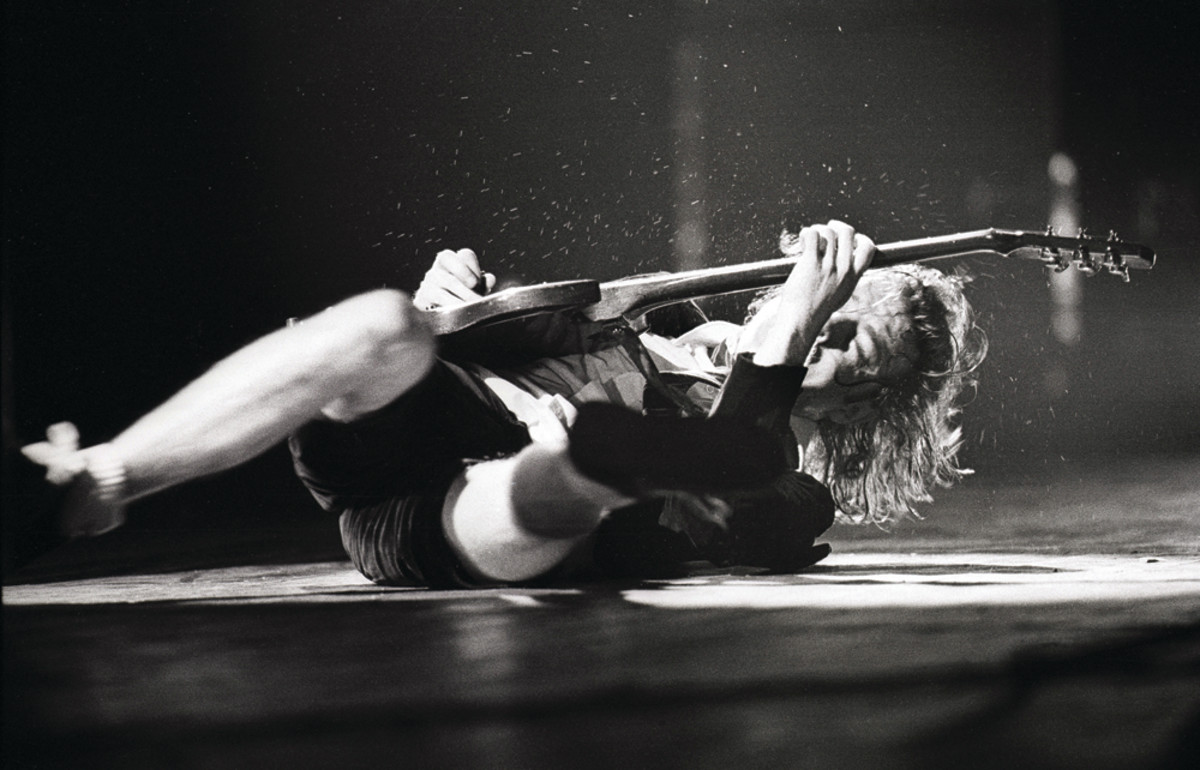 Angus Young having one of his signature schoolboy tantrums onstage, while kicking out a lead. Photo by Rob Verhorst/Redferns. 