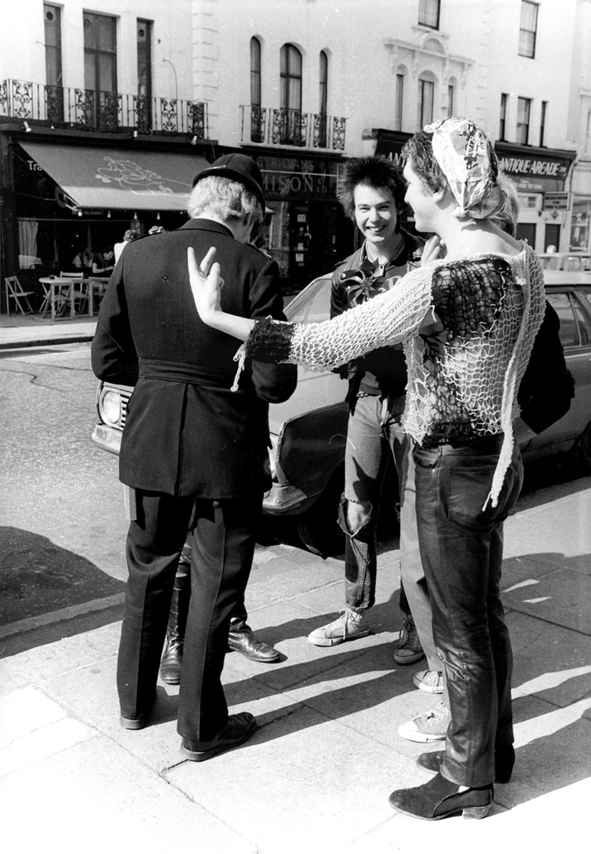 Steve Jones and the Pistols having a laugh with a cop. Photo by Barry Plummer, courtesy of publicity.